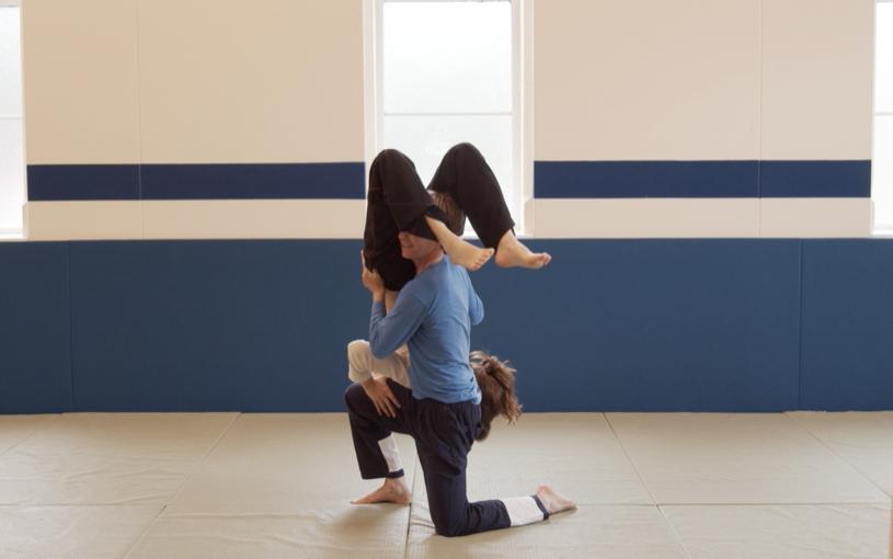 Dancing with Georgicia Pettus: Inverted Georgicia Pettus; kneeling Andrew Wood. In the dojo at South Oxford Community Centre, Oxford, UK. 28 June 2022.