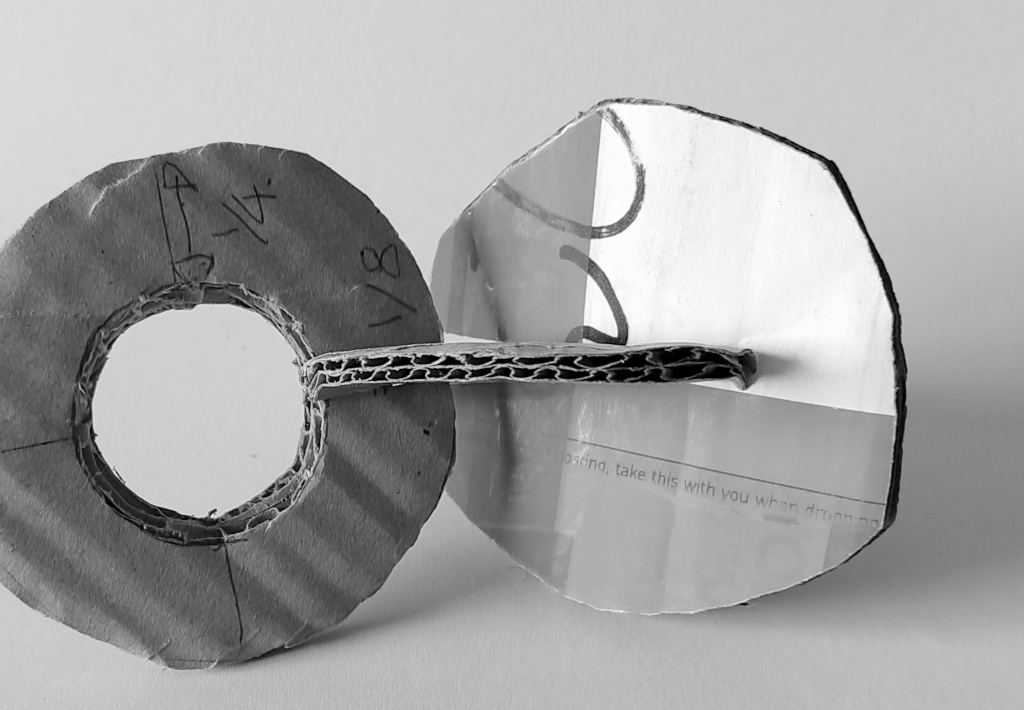 Cardboard model showing three intersecting discs in an assembly (photo ref: IMG_20260519_103804)